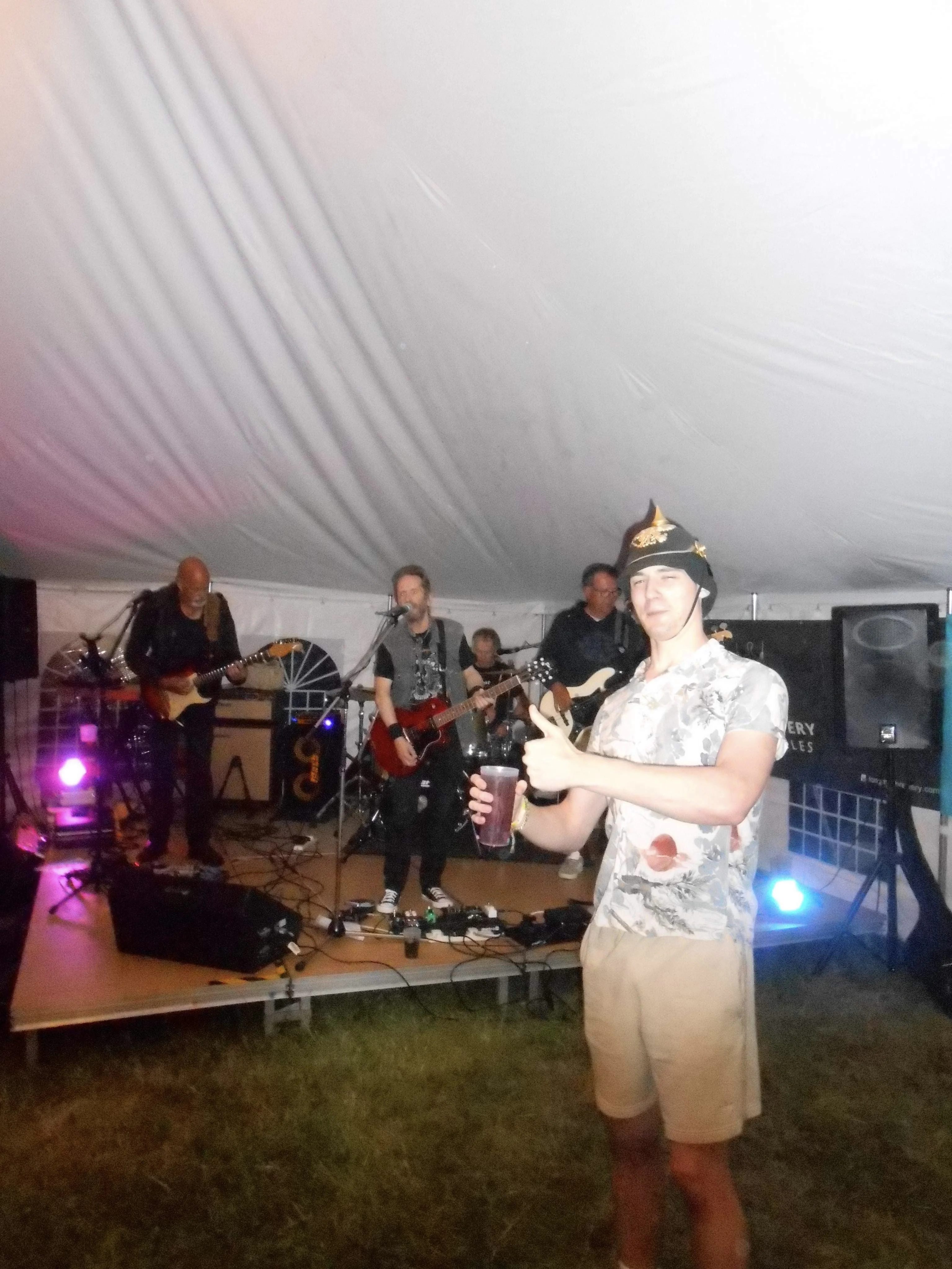 Ryan in front of a live band, thumbs up