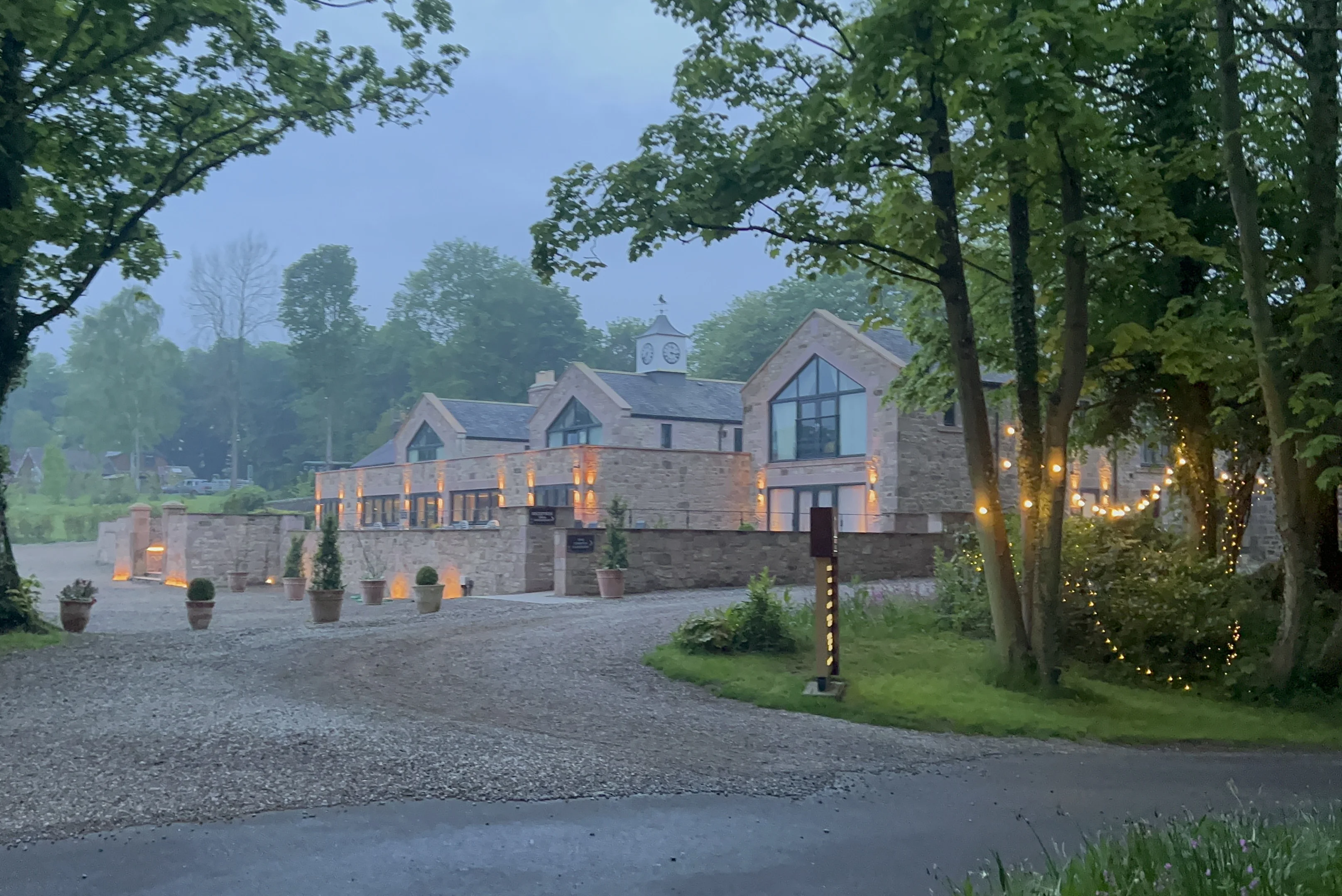 A cozy country hotel with warm lighting and wooden exteriors.