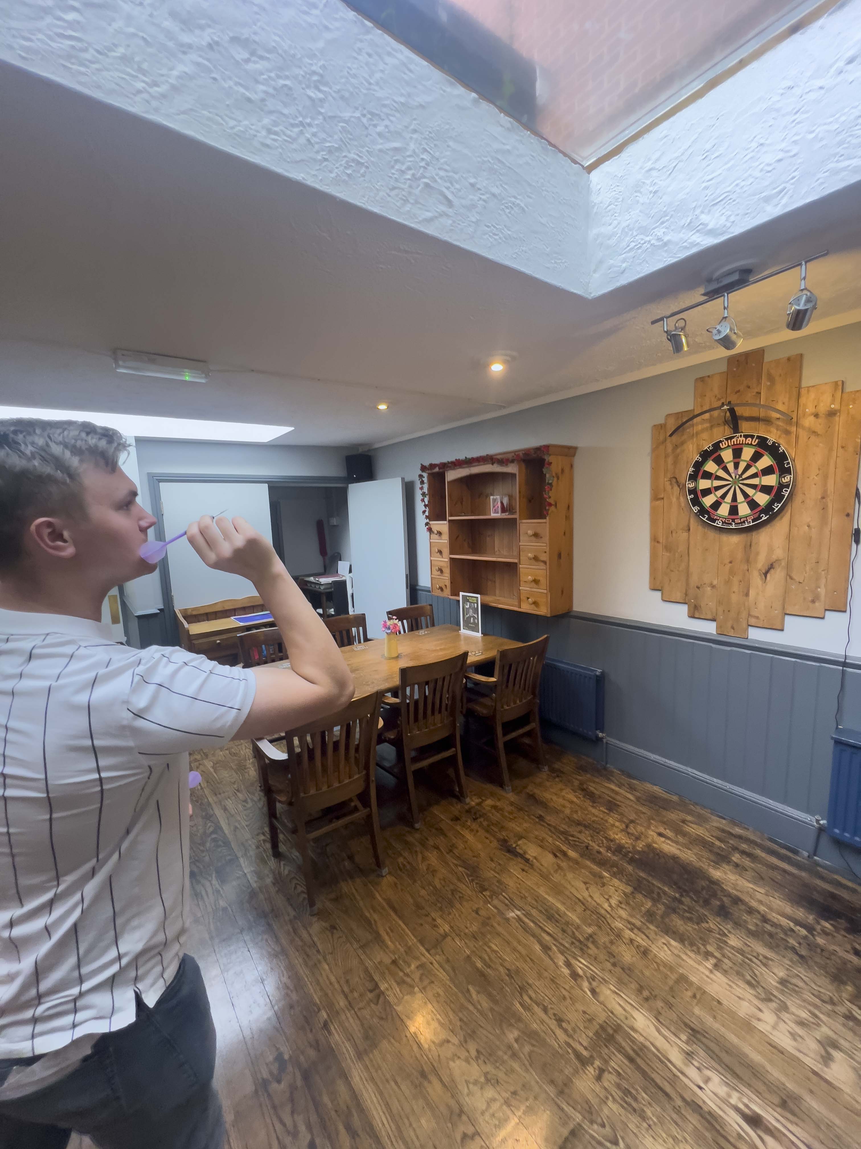 JJ palying darts inside the Volunteer